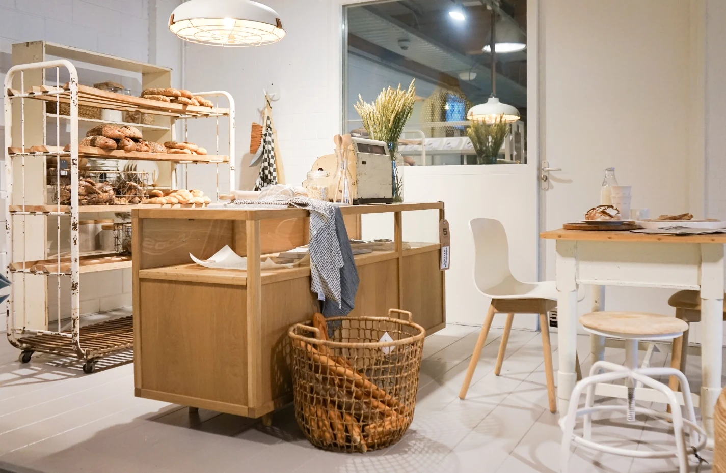 Interior de una panadería con estanterías de pan y cestas de barras